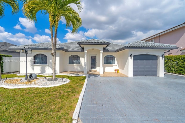 mediterranean / spanish-style home with a garage and a front yard