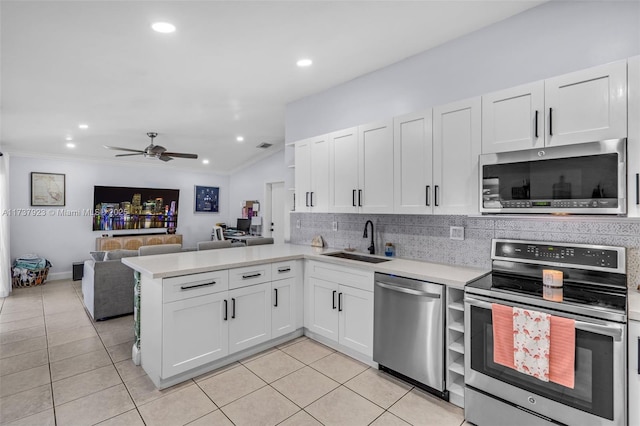 kitchen featuring sink, light tile patterned floors, appliances with stainless steel finishes, white cabinets, and kitchen peninsula