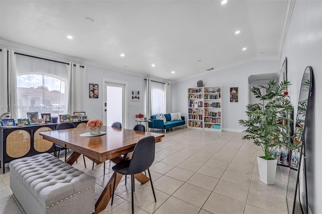 dining room featuring crown molding, lofted ceiling, and light tile patterned floors