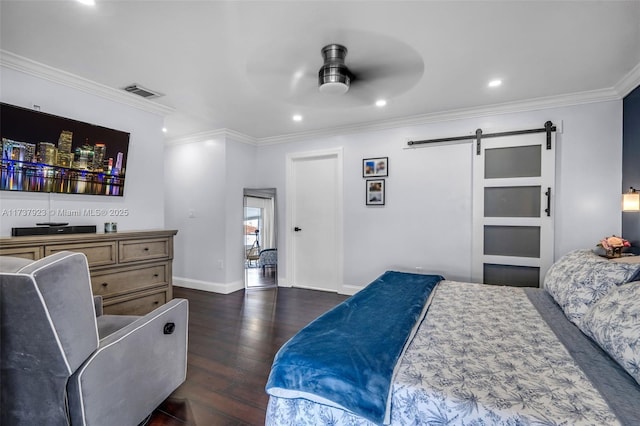 bedroom with ornamental molding, a barn door, dark hardwood / wood-style floors, and ceiling fan