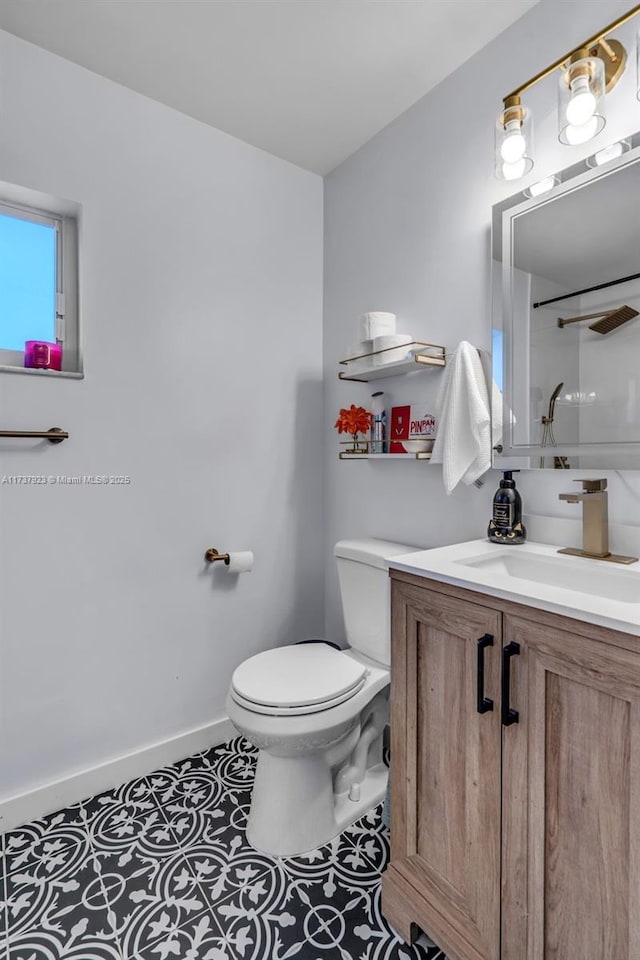 bathroom featuring walk in shower, tile patterned floors, vanity, and toilet