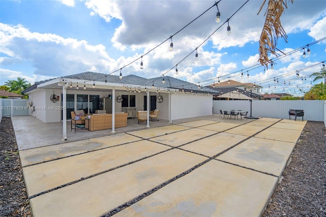 rear view of property featuring an outdoor living space and a patio