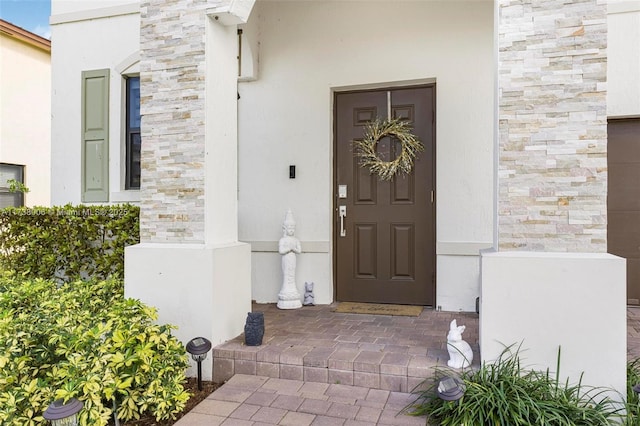 entrance to property with stone siding and stucco siding