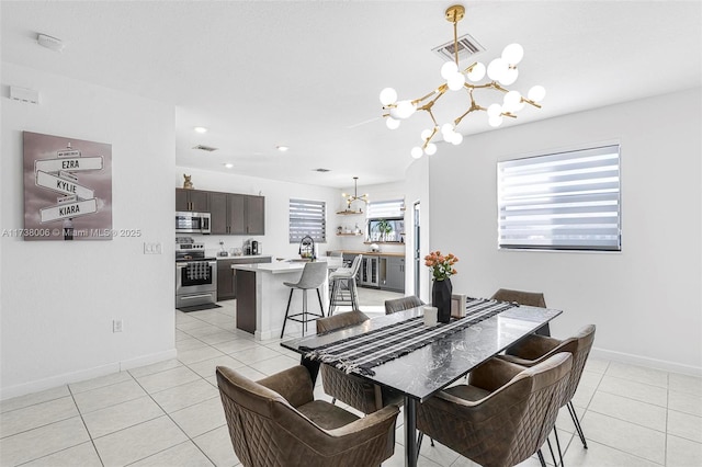 dining room featuring light tile patterned floors, a healthy amount of sunlight, and an inviting chandelier