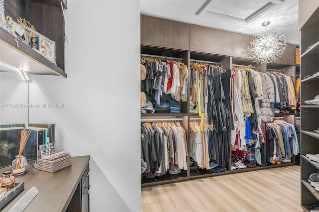 walk in closet featuring light wood-style floors and attic access