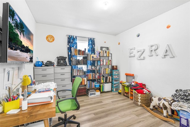 office space with light wood-style floors and a textured ceiling