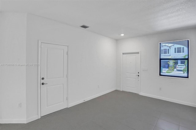 unfurnished room featuring a textured ceiling