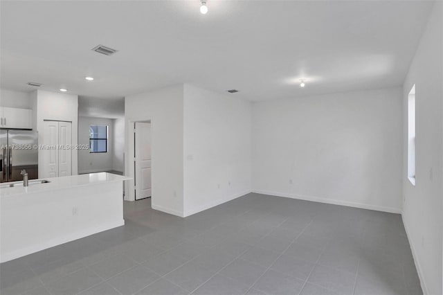 unfurnished room featuring tile patterned floors and sink