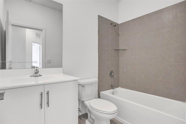 full bathroom with vanity, tiled shower / bath combo, and toilet