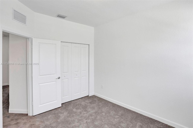 unfurnished bedroom with light carpet and a closet