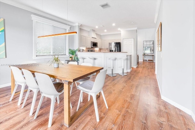 dining space featuring visible vents, crown molding, light wood-type flooring, baseboards, and recessed lighting