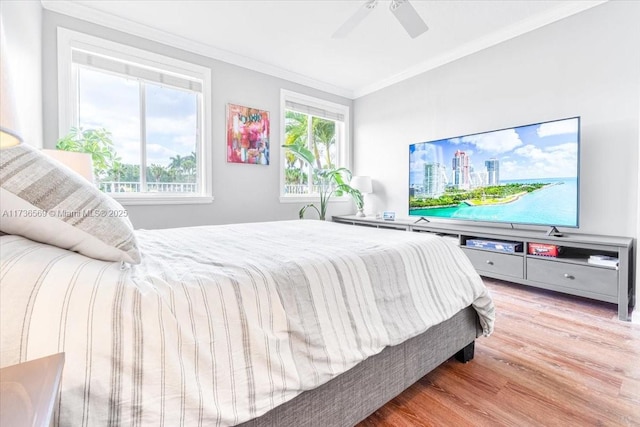 bedroom with crown molding, a ceiling fan, and light wood finished floors