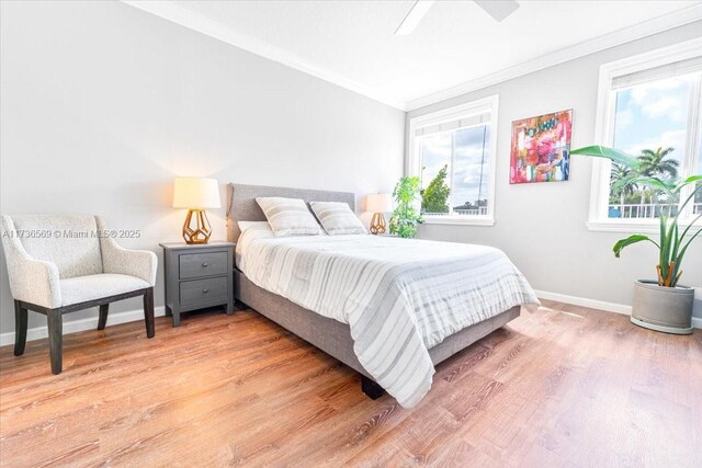 bedroom with crown molding, baseboards, multiple windows, and light wood-type flooring