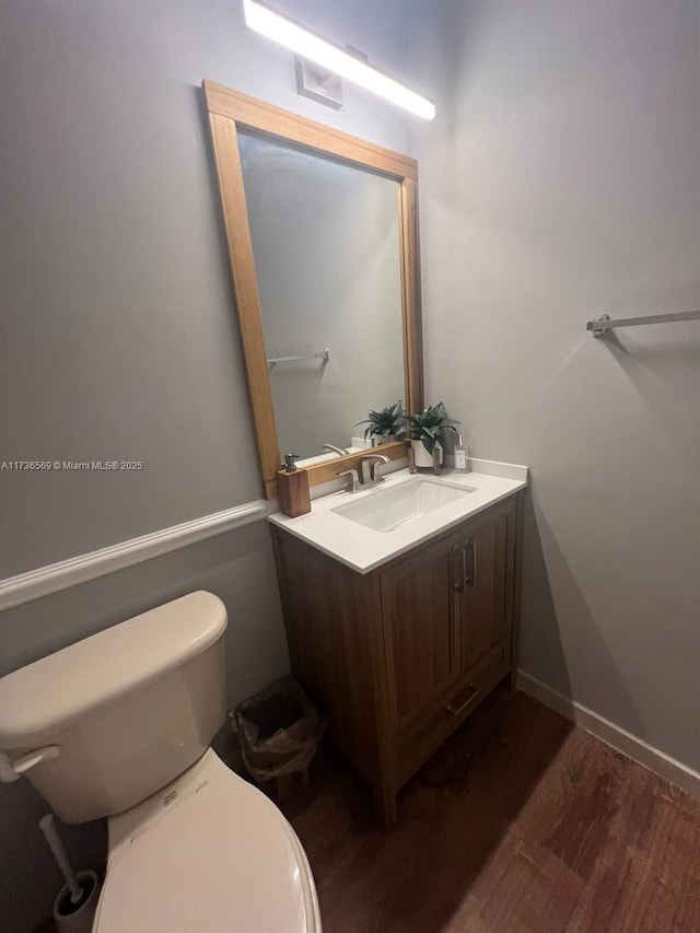 bathroom with vanity, wood-type flooring, and toilet