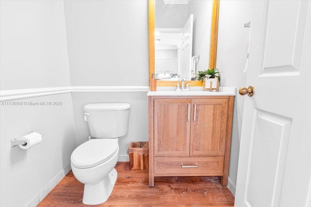 bathroom featuring vanity, wood finished floors, and toilet