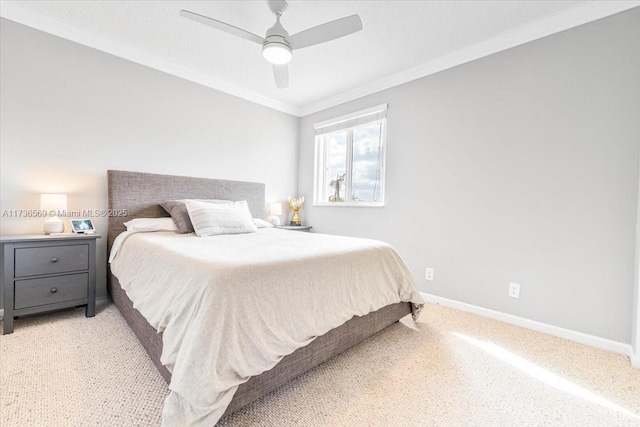 bedroom featuring crown molding, baseboards, light colored carpet, and ceiling fan
