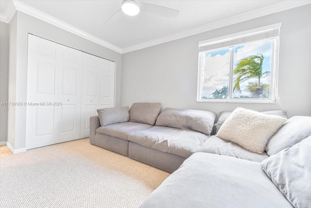 living room with crown molding, carpet flooring, baseboards, and ceiling fan