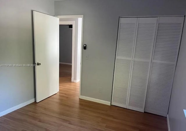 unfurnished bedroom featuring hardwood / wood-style floors and a closet