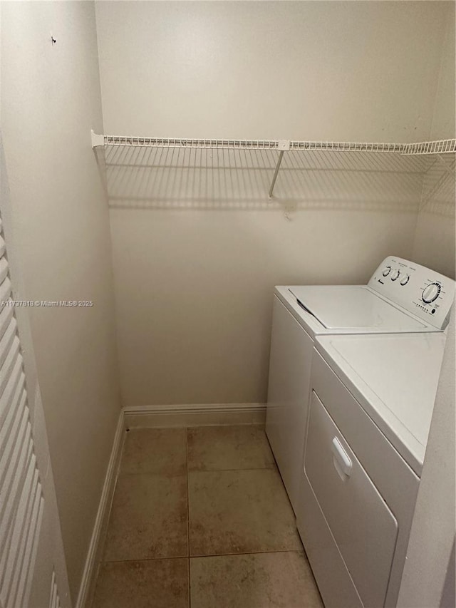 clothes washing area with washer and dryer and light tile patterned floors