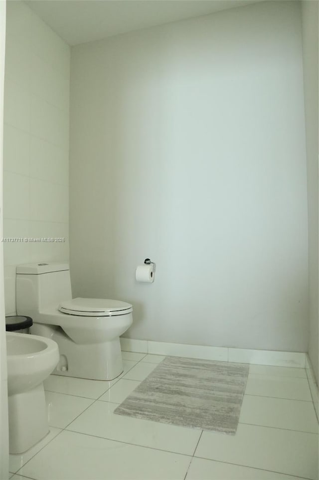 bathroom featuring a bidet, toilet, and tile patterned flooring