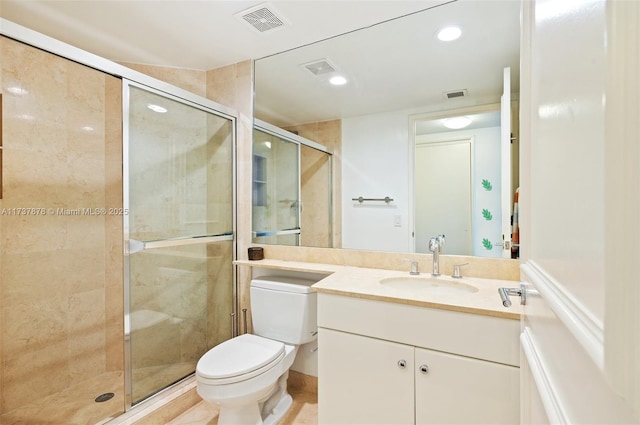 bathroom with vanity, a shower stall, toilet, and visible vents