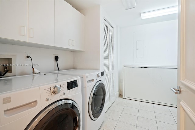 laundry room featuring washing machine and clothes dryer, light tile patterned floors, cabinet space, and electric panel