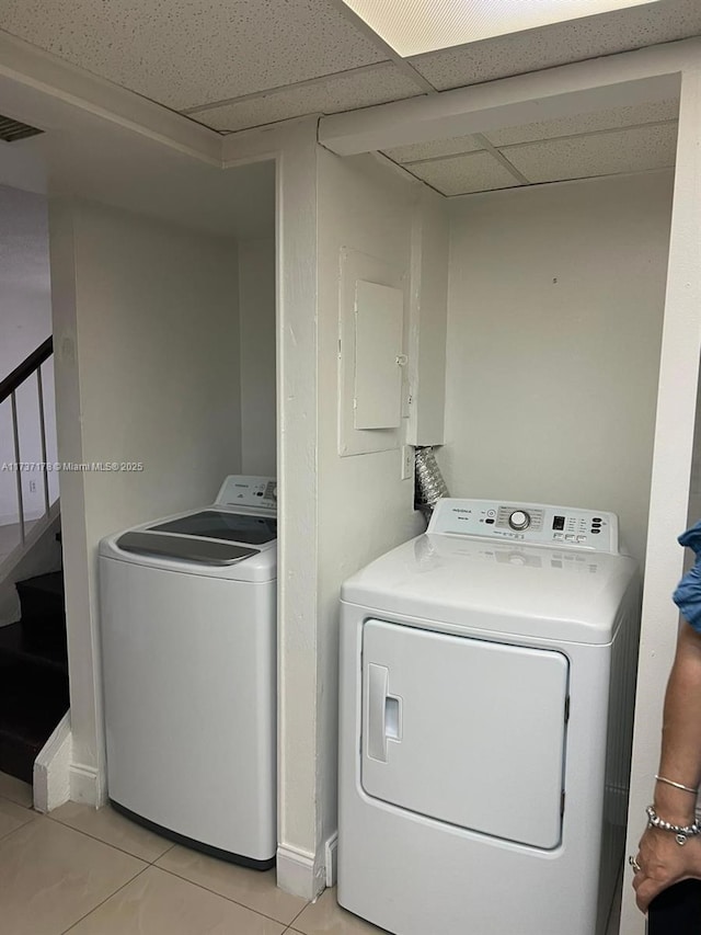 laundry area with washing machine and dryer and light tile patterned floors