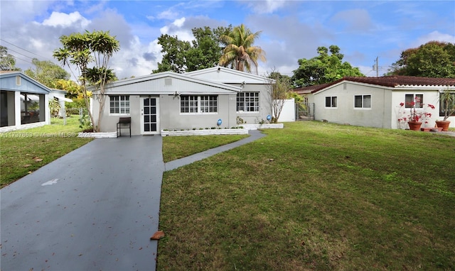 rear view of property featuring a lawn and fence