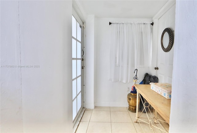 interior space featuring tile patterned flooring and baseboards