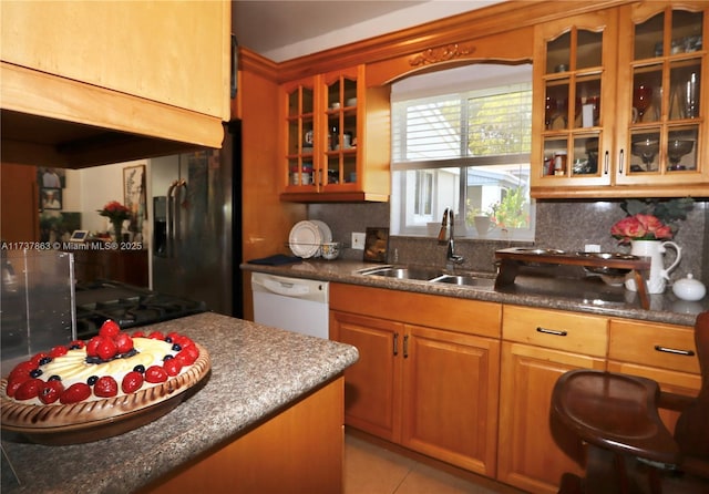 kitchen featuring dishwasher, a sink, black fridge with ice dispenser, and decorative backsplash