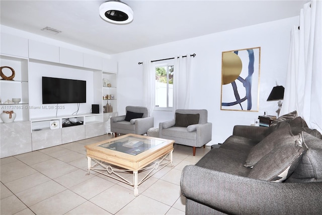 living area with built in features, light tile patterned flooring, and visible vents