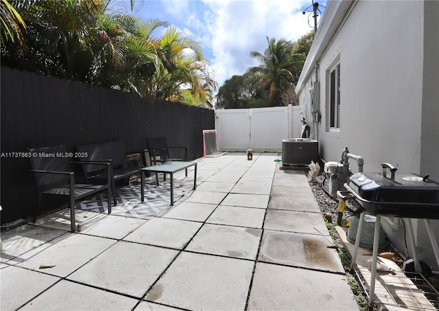 view of patio with a fenced backyard, a gate, and cooling unit