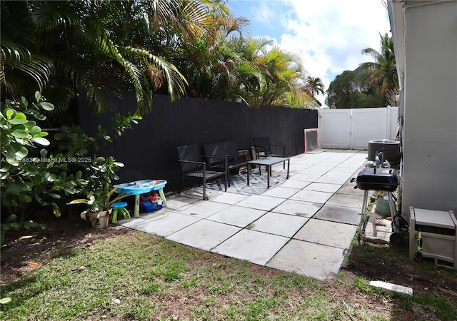 view of patio / terrace featuring a gate, fence, area for grilling, and central AC unit