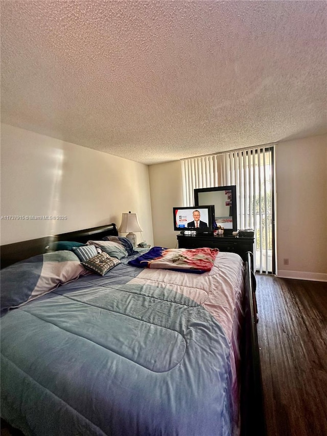 bedroom featuring dark wood-type flooring and a textured ceiling