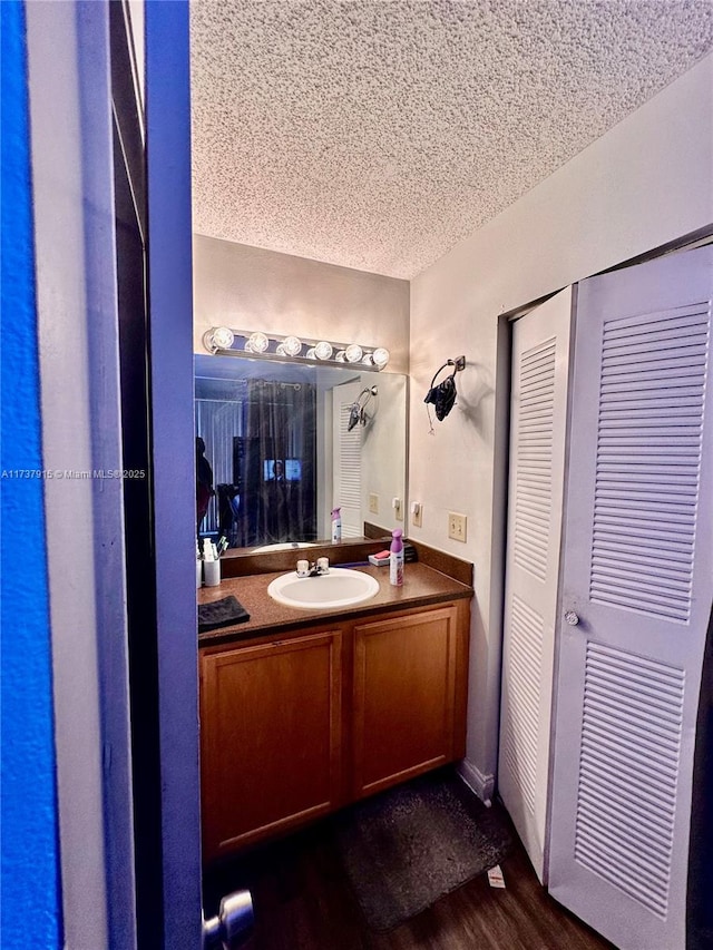 bathroom with vanity, wood-type flooring, and a textured ceiling