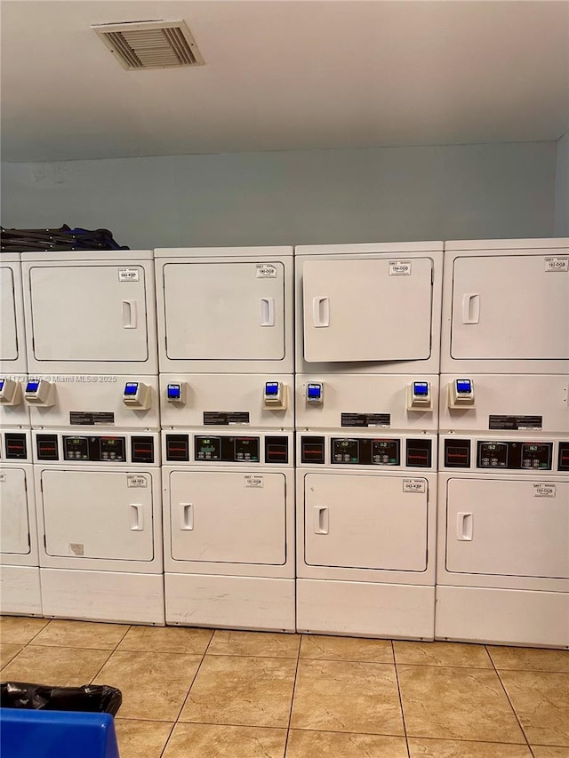 laundry room with washer and dryer, light tile patterned floors, stacked washer and clothes dryer, and mail boxes