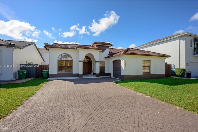 mediterranean / spanish-style home featuring a garage and a front yard