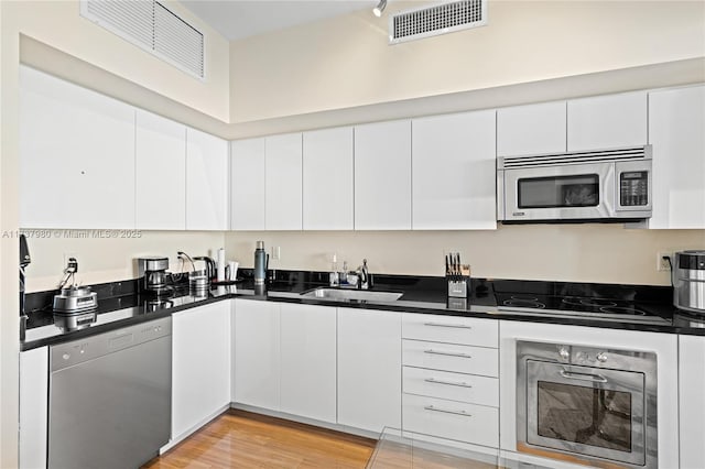 kitchen featuring sink, stainless steel appliances, white cabinets, and light wood-type flooring