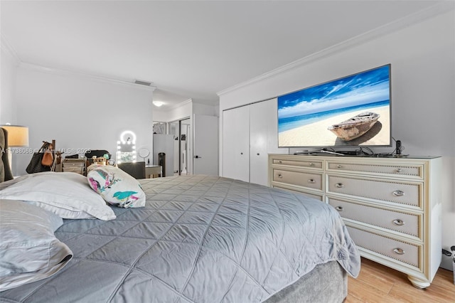 bedroom with multiple closets, ornamental molding, stainless steel fridge, and light hardwood / wood-style floors