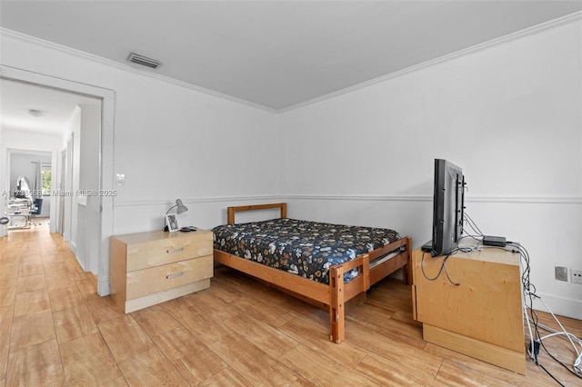 bedroom featuring crown molding and light hardwood / wood-style flooring