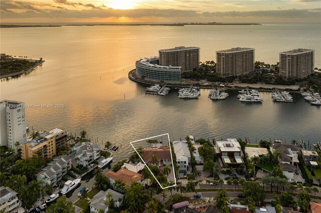 aerial view at dusk featuring a water view