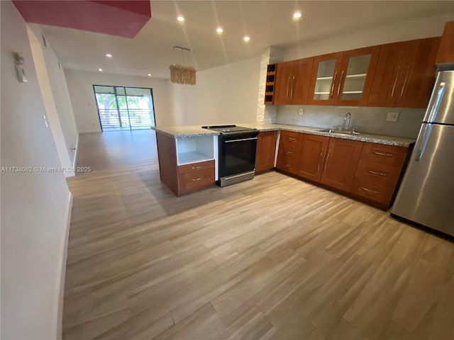 kitchen with sink, stainless steel refrigerator, range with electric cooktop, kitchen peninsula, and light wood-type flooring