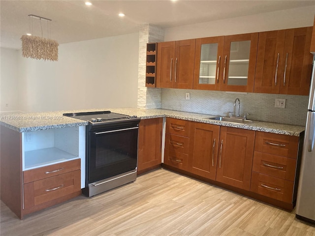 kitchen with sink, light stone counters, range with electric stovetop, decorative backsplash, and light wood-type flooring