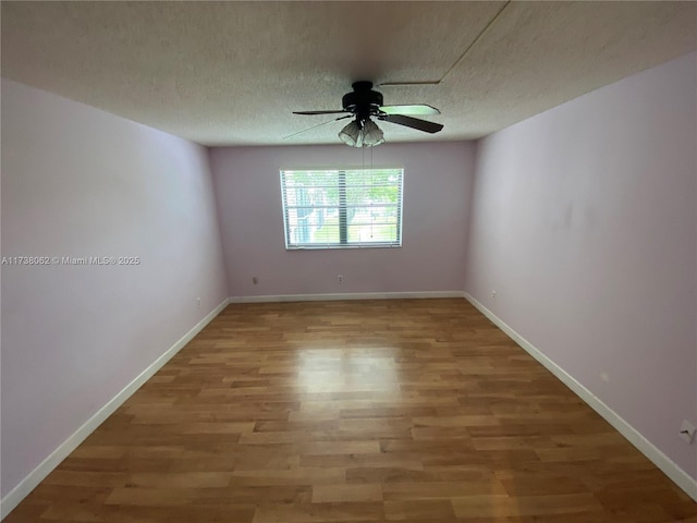 empty room featuring ceiling fan, wood-type flooring, and a textured ceiling