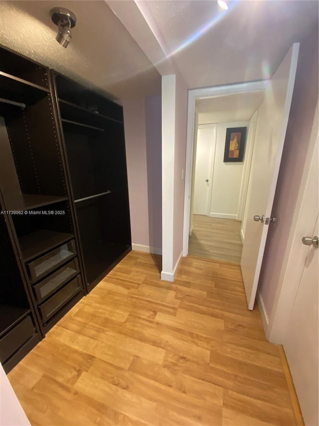 corridor with light hardwood / wood-style flooring