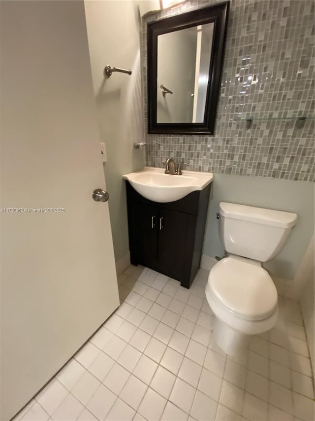 bathroom featuring vanity, toilet, tile patterned floors, and decorative backsplash