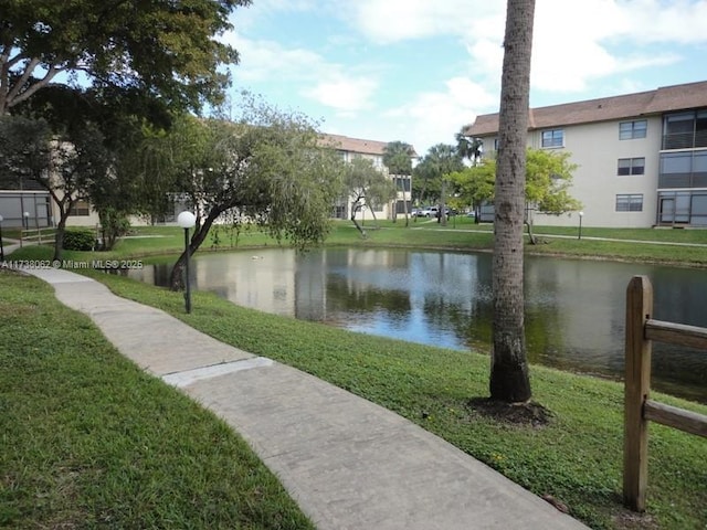 view of home's community featuring a water view and a yard