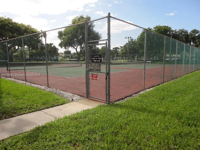 view of sport court with a lawn