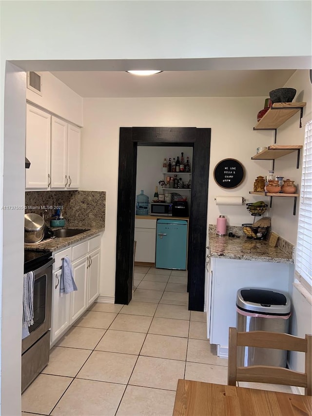 15310 Jackson Dr, Homestead, FL 33033 - kitchen featuring stainless steel appliances, light tile patterned flooring, white cabinets, open shelves, and backsplash