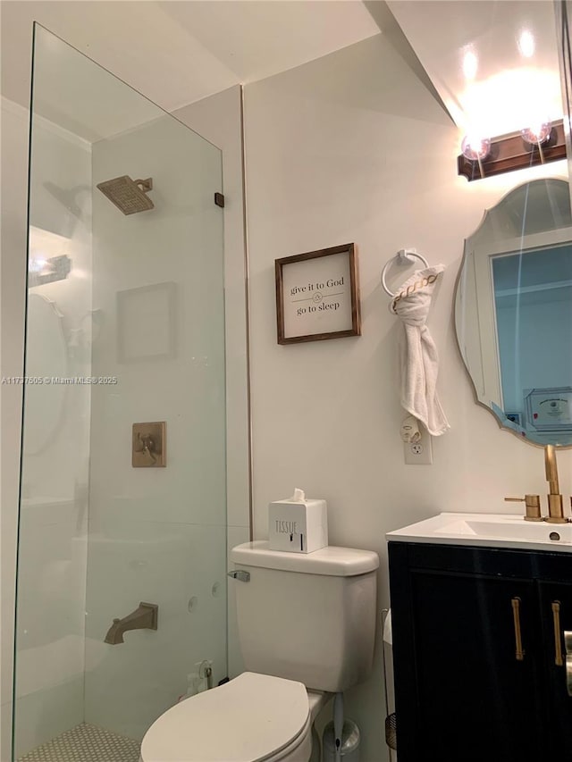 bathroom with vanity, tiled shower, and toilet